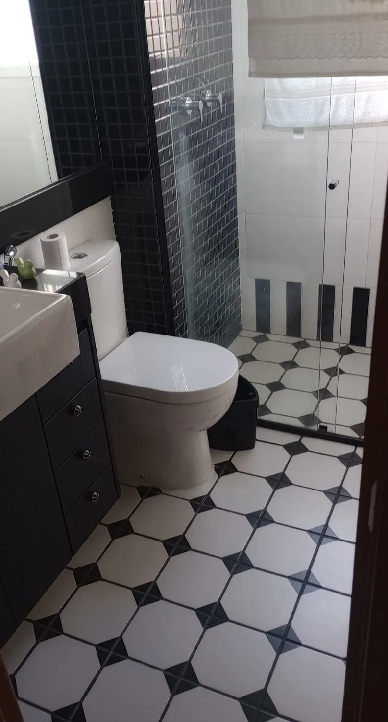 Banheiro preto e branco com box de vidro