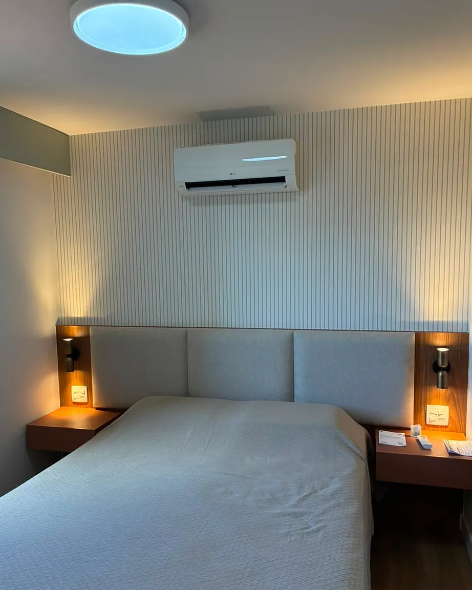 Quarto com cabeceira e iluminação de leitura